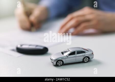 Neues Autokonzept kaufen - Vertragsabschluss im Händlerbüro Stockfoto