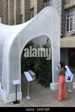 Bangkok, Thailand. Februar 2020. Ein Besucher steht vor dem weißen Pavillon 'Safezone Shelter' vor einem alten Postgebäude im Rahmen eines Designfestivals. Der Pavillon wird technisch belüftet und die Pflanzen sorgen auch für ein Wohlfühlklima, in dem man tief atmen kann. Bis zum 08.02.2020 wird das Festival in der ganzen Stadt weiterhin Design und Kreativität zeigen - mit Filmen, Ausstellungen, Live-Musik und Workshops. (Zu dpa "EIN Design-Festival, das den Atem fangen soll") Credit: Caroline Bock / dpa / Alamy Live News Stockfoto