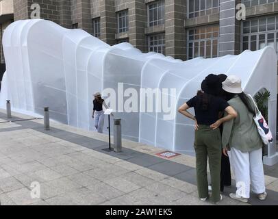 Bangkok, Thailand. Februar 2020. Besucher stehen vor dem weißen Pavillon 'Safezone Shelter' vor einem alten Postgebäude im Rahmen eines Designfestivals. Der Pavillon wird technisch belüftet und die Pflanzen sorgen auch für ein Wohlfühlklima, in dem man tief atmen kann. Bis zum 08.02.2020 wird das Festival in der ganzen Stadt weiterhin Design und Kreativität zeigen - mit Filmen, Ausstellungen, Live-Musik und Workshops. (Zu dpa "EIN Design-Festival, das den Atem fangen soll") Credit: Caroline Bock / dpa / Alamy Live News Stockfoto