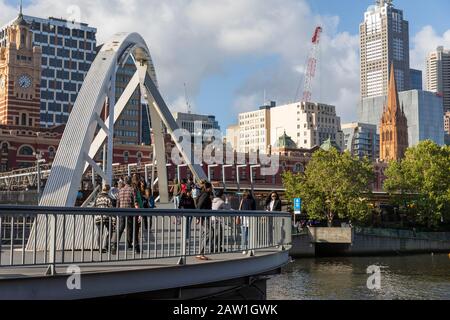 Melbourne, Fußgänger überqueren den yarra River auf der evan Walker-Fußgängerbrücke in Richtung melbourne City Centre, Australien Stockfoto