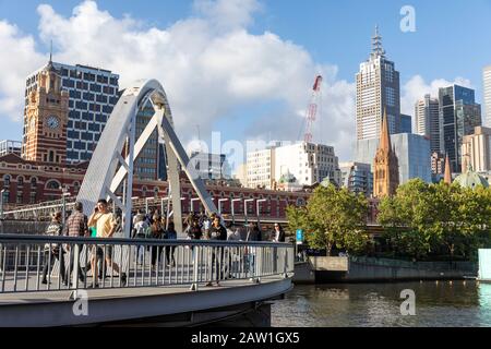 Fußgänger im Stadtzentrum von Melbourne überqueren den yarra River auf der evan Walker-Brücke, Victoria, Australien Stockfoto