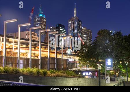 Flinders Street Bahnhof nachts im Stadtzentrum von Melbourne mit beleuchteten Bürohaustürmen, Victoria, Australien Stockfoto