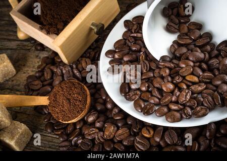 Kaffeebohnen mit Mahlwerk, Kaffeetasse und Rohrzucker Stockfoto