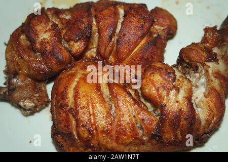 Gebratene, gegrillte Hühnerstücke mit marinierten Gewürzen darauf. Leckeres gebratenes Hühnergrill Stockfoto