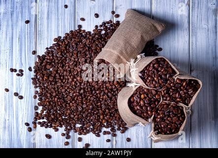 Kaffeesamen mit einigen Jutebeuteln, die mit Kaffeebohnen gefüllt sind. Stockfoto