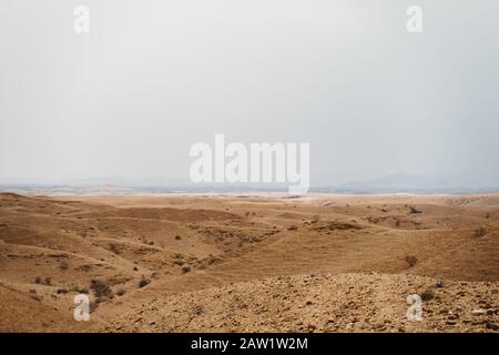 Tote Mondlandschaft mit orangefarbenen Felsen, Steinen und Bergen Stockfoto