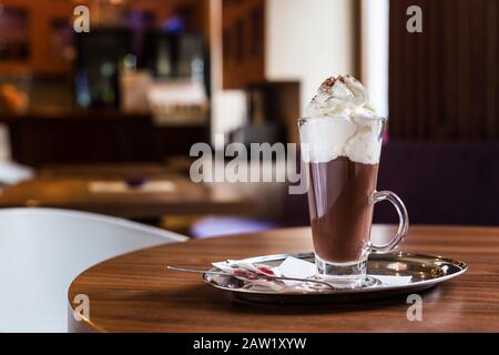Kaffee mit Schlagsahne. Zimt und Zucker. Warten auf Freunde in einem Coffeeshop. Stockfoto