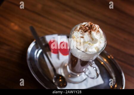 Kaffee mit Schlagsahne. Zimt und Zucker. Warten auf Freunde in einem Coffeeshop. Stockfoto