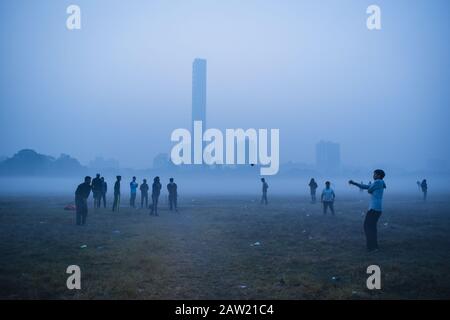 Die Menschen spielen Fußball und machen an einem Morgen Übungen in Kolkata, Indien. Stockfoto