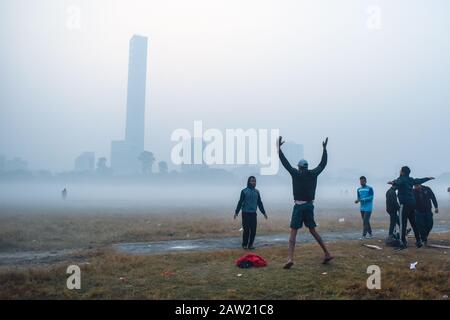 Die Menschen spielen Fußball und machen an einem Morgen Übungen in Kolkata, Indien. Stockfoto