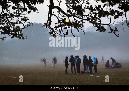 Die Menschen spielen Fußball und machen an einem Morgen Übungen in Kolkata, Indien. Stockfoto