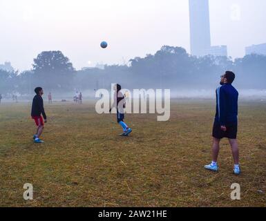 Die Menschen spielen Fußball und machen an einem Morgen Übungen in Kolkata, Indien. Stockfoto