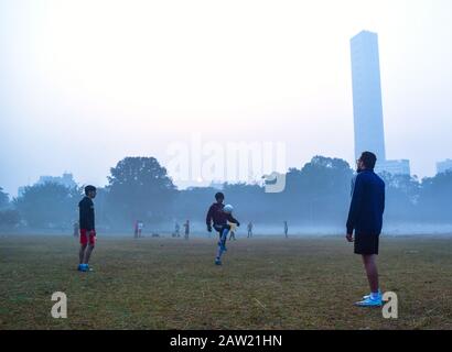 Die Menschen spielen Fußball und machen an einem Morgen Übungen in Kolkata, Indien. Stockfoto