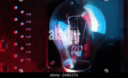 Schöne Glühbirne aus Wolfram in blauen und roten abstrakten Lichtern. Idee. Stockfoto