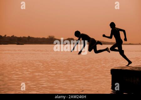 Junge Jungen in Indien, die am Fluss spielen Stockfoto