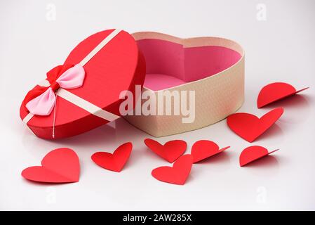Happy Valentinstag, Valentinstag Hintergrund, geöffneter Geschenkkasten in Herzform mit Band und kleinen Papierherzen, auf weißem Hintergrund, Valentinstag c Stockfoto