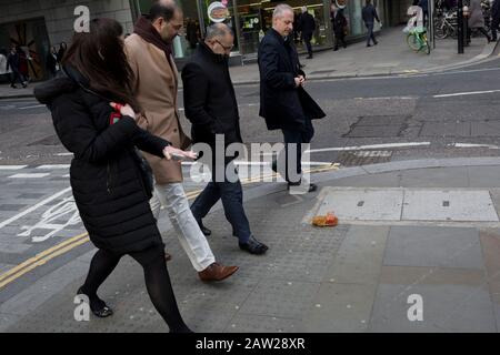 Fußgänger vermeiden einen Nudel- und Sauce-Mitnahme, fallen gelassen und während der Mittagsstunde im Finanzviertel der Hauptstadt am 4. Februar 2020 in der City of London, England, auf dem Straßenbelag entsorgt. Die Mittagsmahlzeit wurde auf der Straße getragen, als ihre Hitze und Feuchtigkeit es durch den Boden einer Papiertüte fallen ließen, sie umgedreht und perfekt auf dem Straßenbelag liegend, als die Stadtarbeiter aus ihren Büros auftauchten. Diejenigen, die es rechtzeitig sahen, traten über das schmierige Hindernis, aber die ablenkten (meist durch das gehen mit Telefonen zu Ohren), traten in es und halfen, es über den Straßenbelag zu verbreiten. Stockfoto