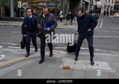 Fußgänger vermeiden einen Nudel- und Sauce-Mitnahme, fallen gelassen und während der Mittagsstunde im Finanzviertel der Hauptstadt am 4. Februar 2020 in der City of London, England, auf dem Straßenbelag entsorgt. Die Mittagsmahlzeit wurde auf der Straße getragen, als ihre Hitze und Feuchtigkeit es durch den Boden einer Papiertüte fallen ließen, sie umgedreht und perfekt auf dem Straßenbelag liegend, als die Stadtarbeiter aus ihren Büros auftauchten. Diejenigen, die es rechtzeitig sahen, traten über das schmierige Hindernis, aber die ablenkten (meist durch das gehen mit Telefonen zu Ohren), traten in es und halfen, es über den Straßenbelag zu verbreiten. Stockfoto