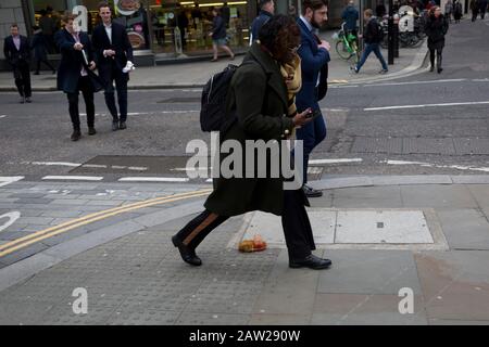 Fußgänger vermeiden einen Nudel- und Sauce-Mitnahme, fallen gelassen und während der Mittagsstunde im Finanzviertel der Hauptstadt am 4. Februar 2020 in der City of London, England, auf dem Straßenbelag entsorgt. Die Mittagsmahlzeit wurde auf der Straße getragen, als ihre Hitze und Feuchtigkeit es durch den Boden einer Papiertüte fallen ließen, sie umgedreht und perfekt auf dem Straßenbelag liegend, als die Stadtarbeiter aus ihren Büros auftauchten. Diejenigen, die es rechtzeitig sahen, traten über das schmierige Hindernis, aber die ablenkten (meist durch das gehen mit Telefonen zu Ohren), traten in es und halfen, es über den Straßenbelag zu verbreiten. Stockfoto