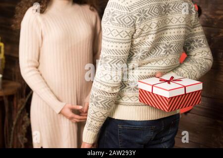 3/4-Ansicht des Mannes, der Freundin am valentinstag ein Geschenk überreicht. Stockfoto