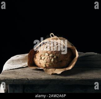 Gebackenes Ovalbrot aus Roggenmehl mit Kürbiskernen, schwarzer Hintergrund Stockfoto