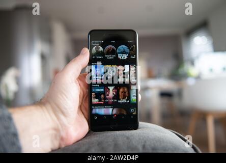 Amsterdam, Niederlande, 02/06/2020, Mann mit iphone 8 Plus, Netflix Startbildschirm auf Handy. Netflix Online-Video, Content Streaming Subsc Stockfoto