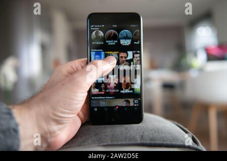 Amsterdam, Niederlande, 02/06/2020, Mann mit iphone 8 Plus, Netflix Startbildschirm auf Handy. Netflix Online-Video, Content Streaming Subsc Stockfoto