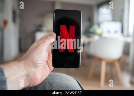 Amsterdam, Niederlande, 02/06/2020, Mann mit iphone 8 Plus, Netflix Startbildschirm auf Handy. Netflix Online-Video, Content Streaming Subsc Stockfoto