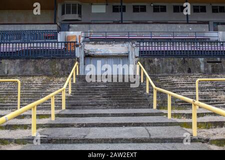 Altes Stadion für viele Zuschauer. Verlassene Tribünen und Gebäude Stockfoto