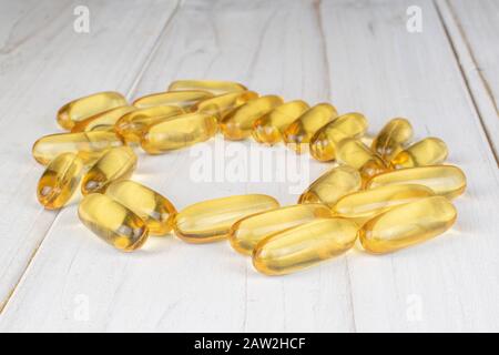 Viel goldenes Fischöl auf weißem Holz Stockfoto