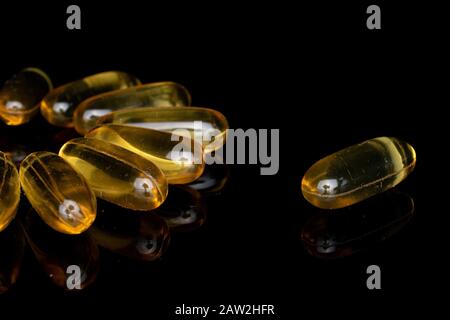 Auf schwarzem Glas wurde jede Menge goldener Fischölblume isoliert Stockfoto