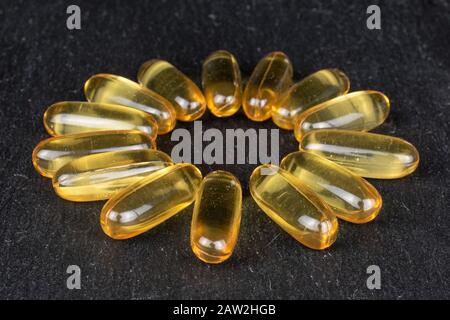 Viel goldenes Fischöl auf grauem Stein Stockfoto