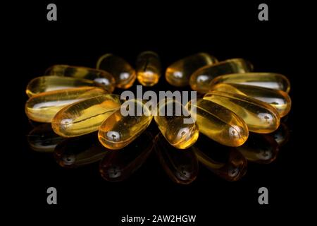 Auf schwarzem Glas wurde jede Menge goldener Fischölblume isoliert Stockfoto