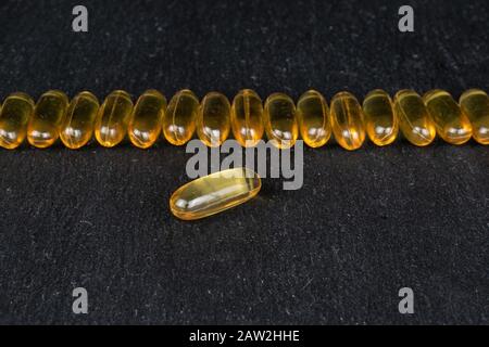 Jede Menge goldenes Fischöl, das auf grauem Stein konzentriert ist Stockfoto