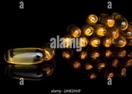 Auf schwarzem Glas wurde viel goldenes Fischöl isoliert Stockfoto