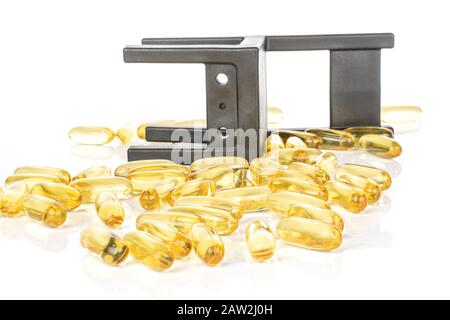 Viel goldenes Fischöl mit schwarzem Stuhl isoliert auf weißem Grund Stockfoto