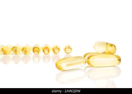 Viele ganze goldene Fischölkapseln isoliert auf weißem Grund Stockfoto