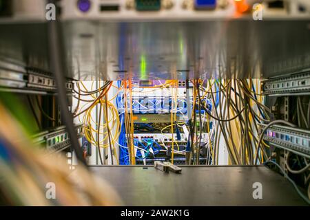 Die Netzwerkausrüstung des ISP befindet sich im Rechenzentrum. Zwischen Servern sind viele Kabel gestapelt. Die Kommunikationskabel und den Glasfaser-Patch Stockfoto