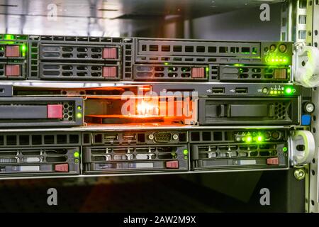 Ein Server mit mehreren Festplatten funktioniert in einem Datacenter-Rack. Ein Ort zum Anschließen der festplatte. Helle Anzeige eines funktionierenden Computers Stockfoto