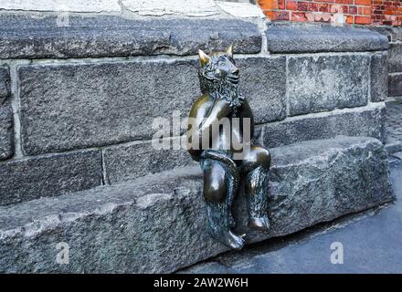 Der niedliche kleine Teufel sitzt auf einem Stein vor der Marienkirche (St. Marienkirche), Lübeck. Stockfoto