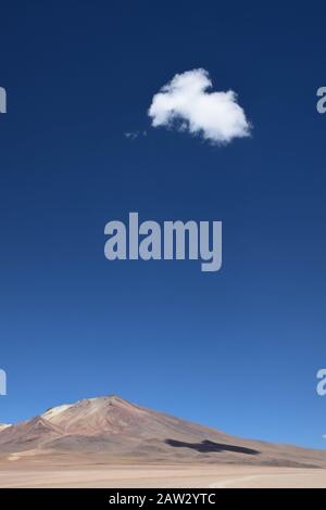 Eine einzige Wolke im klaren blauen Himmel, die auf einer Bergseite in der Landschaft des bolivianischen Hochlandes Schatten erzeugt. In der Nähe der wüste salvador dali in Th Stockfoto