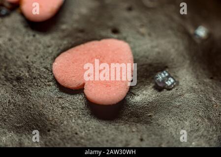 Kleiner schöner kleiner Kuchen mit Schokoladenbuchstaben und littl Hearts Pink Little Chocolate Heart auf einem Schokoladenkuchen. Stockfoto