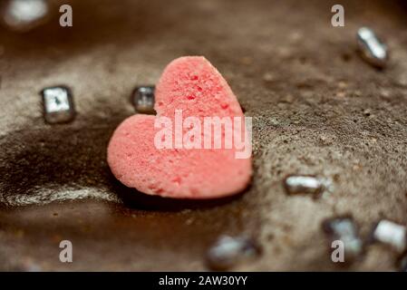 Kleiner schöner kleiner Kuchen mit Schokoladenbuchstaben und littl Hearts Pink Little Chocolate Heart auf einem Schokoladenkuchen. Stockfoto