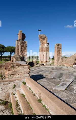 Rom. Italien. Ostia Antica. Terme di Porta Marina (Bäder der Porta Marina). Ziegelpfeiler der Apse, Stufen führen zum Frigidarium, der Boden ist dez Stockfoto