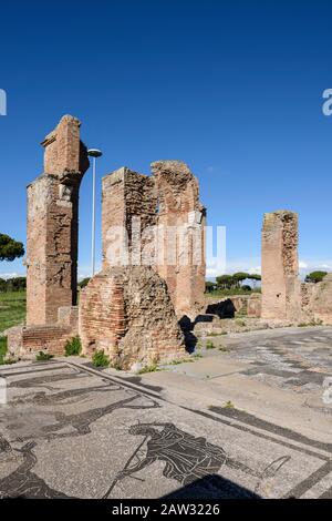 Rom. Italien. Ostia Antica. Terme di Porta Marina (Bäder der Porta Marina). Backstein-Piers der Apse, im Vorraum sind Fußbodenmosaiken, die eine darstellen Stockfoto