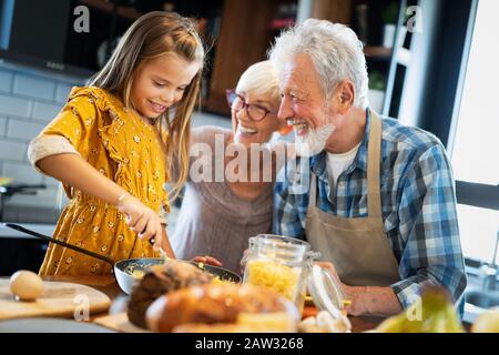 Happy grandchildrens Mädchen frühstücken mit ihren Großeltern Stockfoto