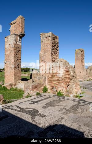 Rom. Italien. Ostia Antica. Terme di Porta Marina (Bäder der Porta Marina). Ziegelpfirsiche der Apse, im Vorraum sind Fußbodenmosaiken, die auf darstellen Stockfoto