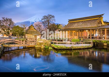 Oshino, Japan historische Strohdachhäuser mit Mt. Fuji im Zwielicht. Stockfoto