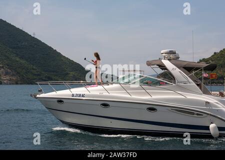 Bikini-Mädchen nimmt selfie auf dem Vordeck eines Motorkreuzers, Boka Kotorska (Bucht von Kotor), Montenegro Stockfoto