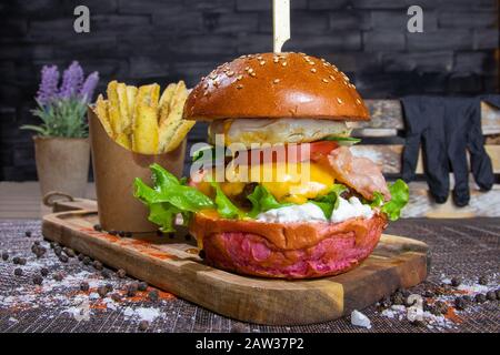 Saftiger Burger auf Holzplatte Stockfoto